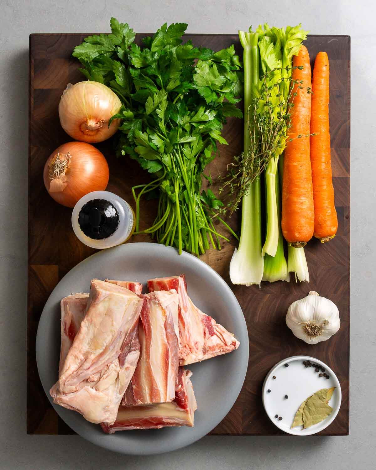 Ingredients shown: onions, parsley, celery, thyme, carrots, olive oil, beef bones, garlic, peppercorns, and bay leaves.