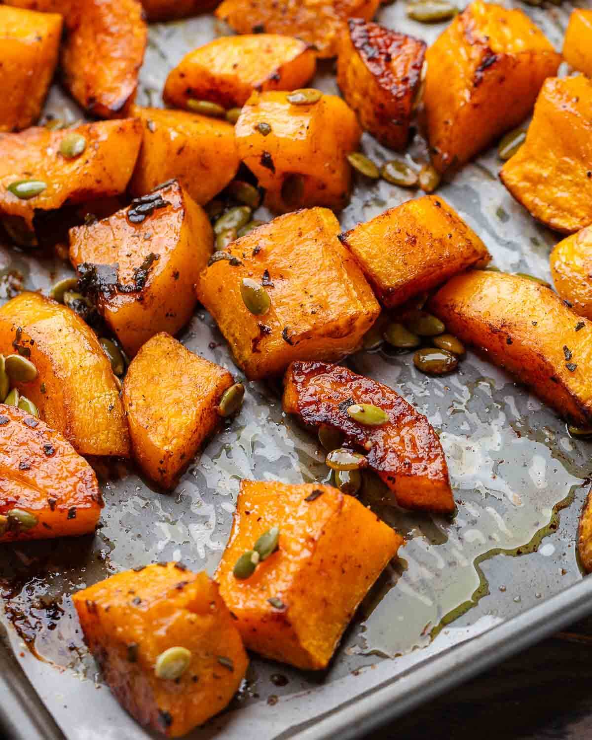 Cinnamon roasted butternut squash on grey baking sheet.