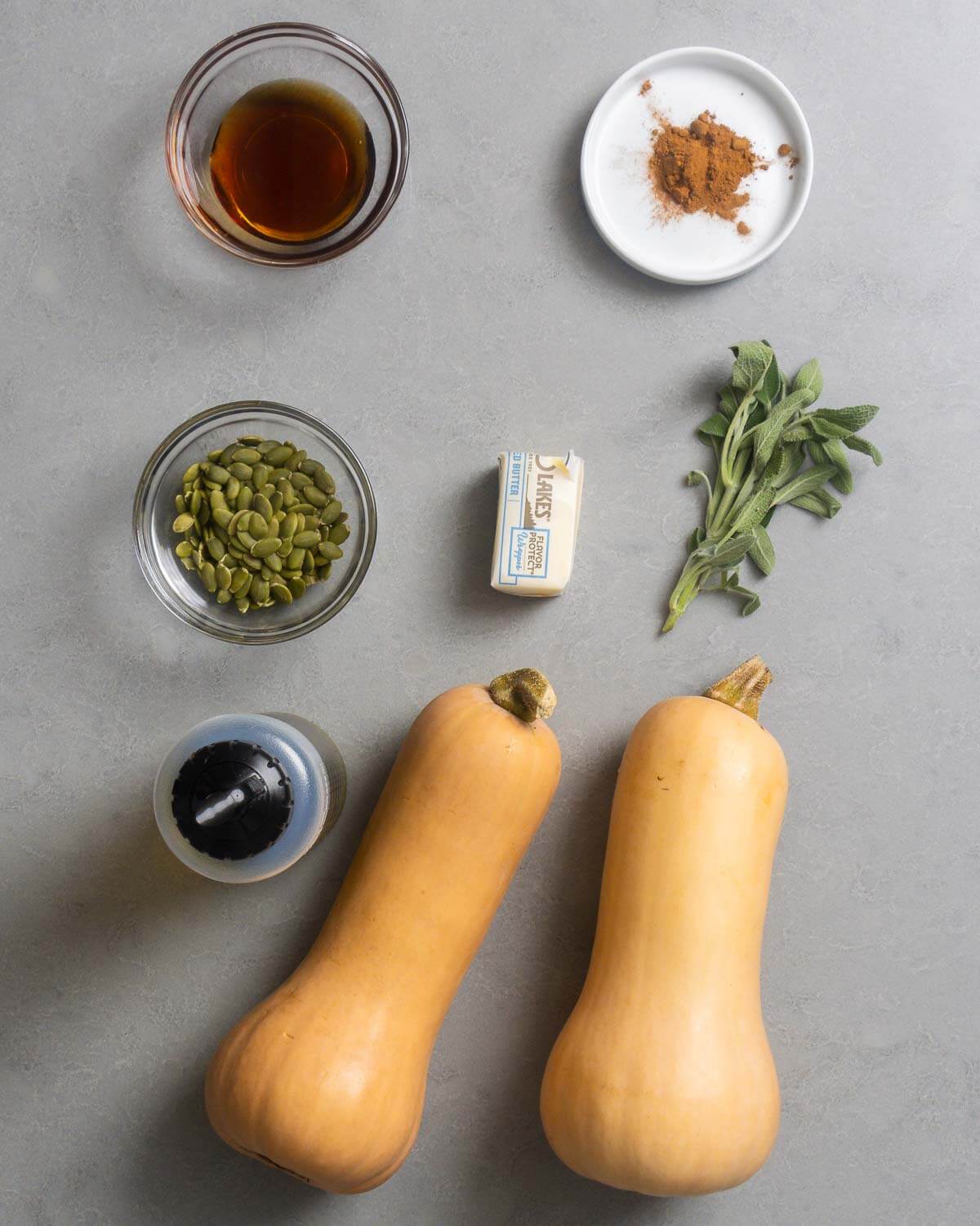 Ingredients shown: maple syrup, cinnamon, pumpkin seeds, butter, sage, olive oil, and butternut squash.
