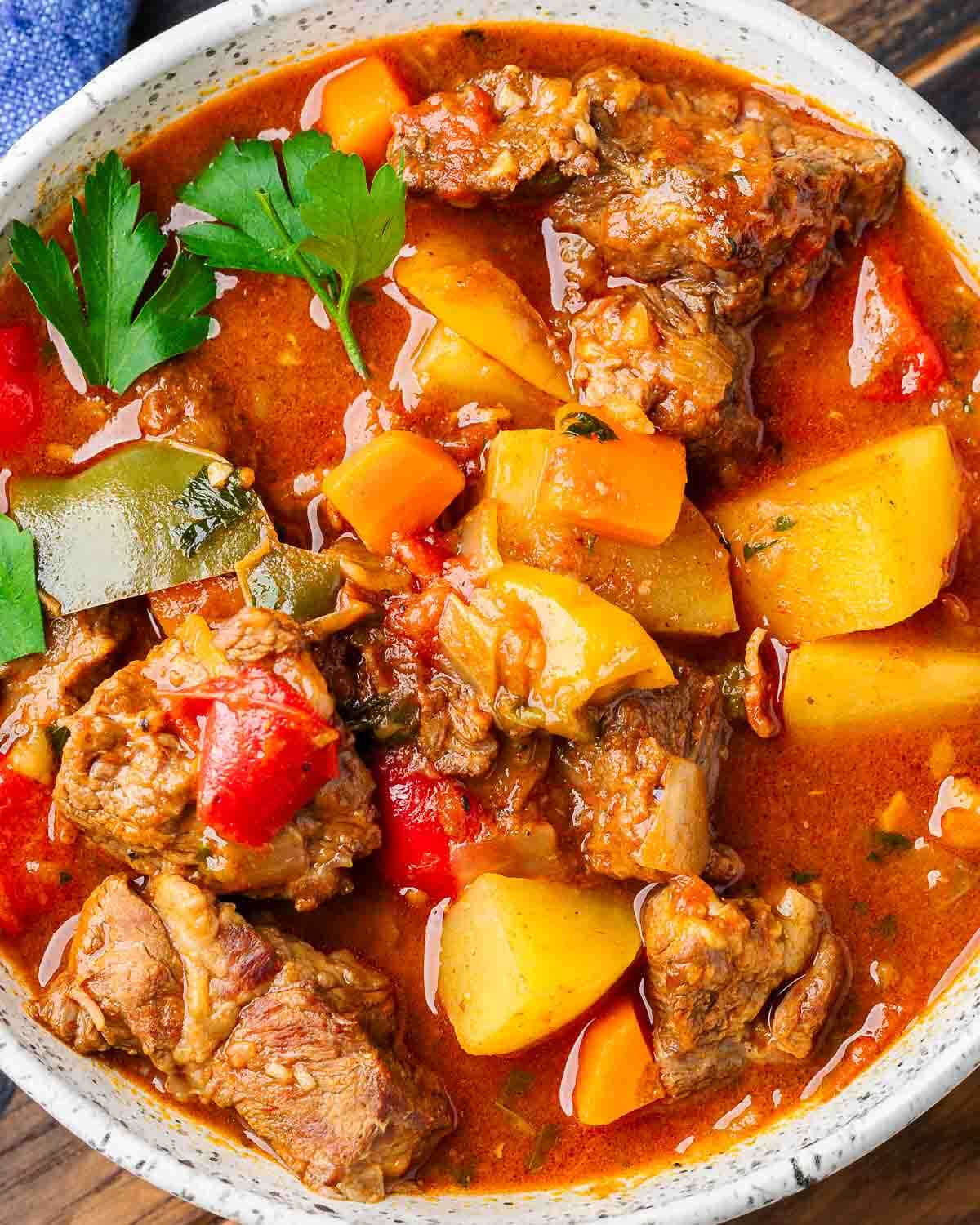 Overhead shot of Hungarian goulash in white bowl.