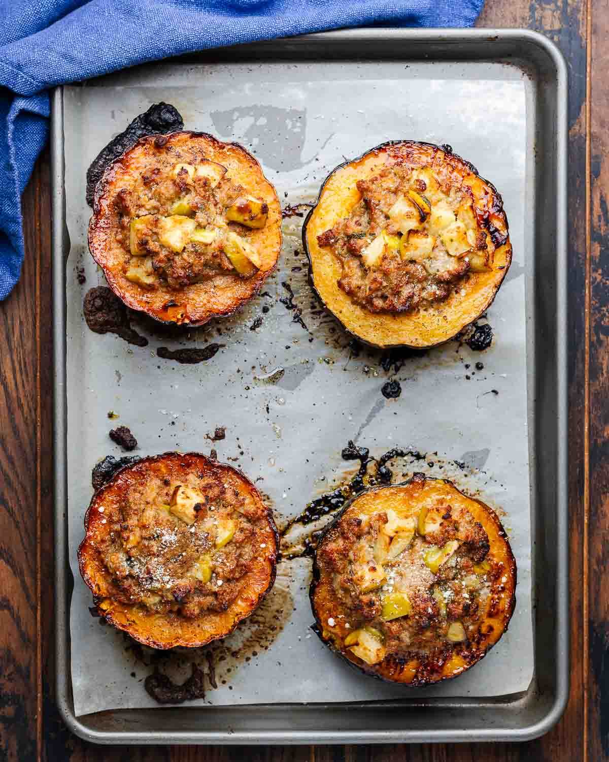 Overhead shot of baking sheet with 4 stuffed acorn squash halves.