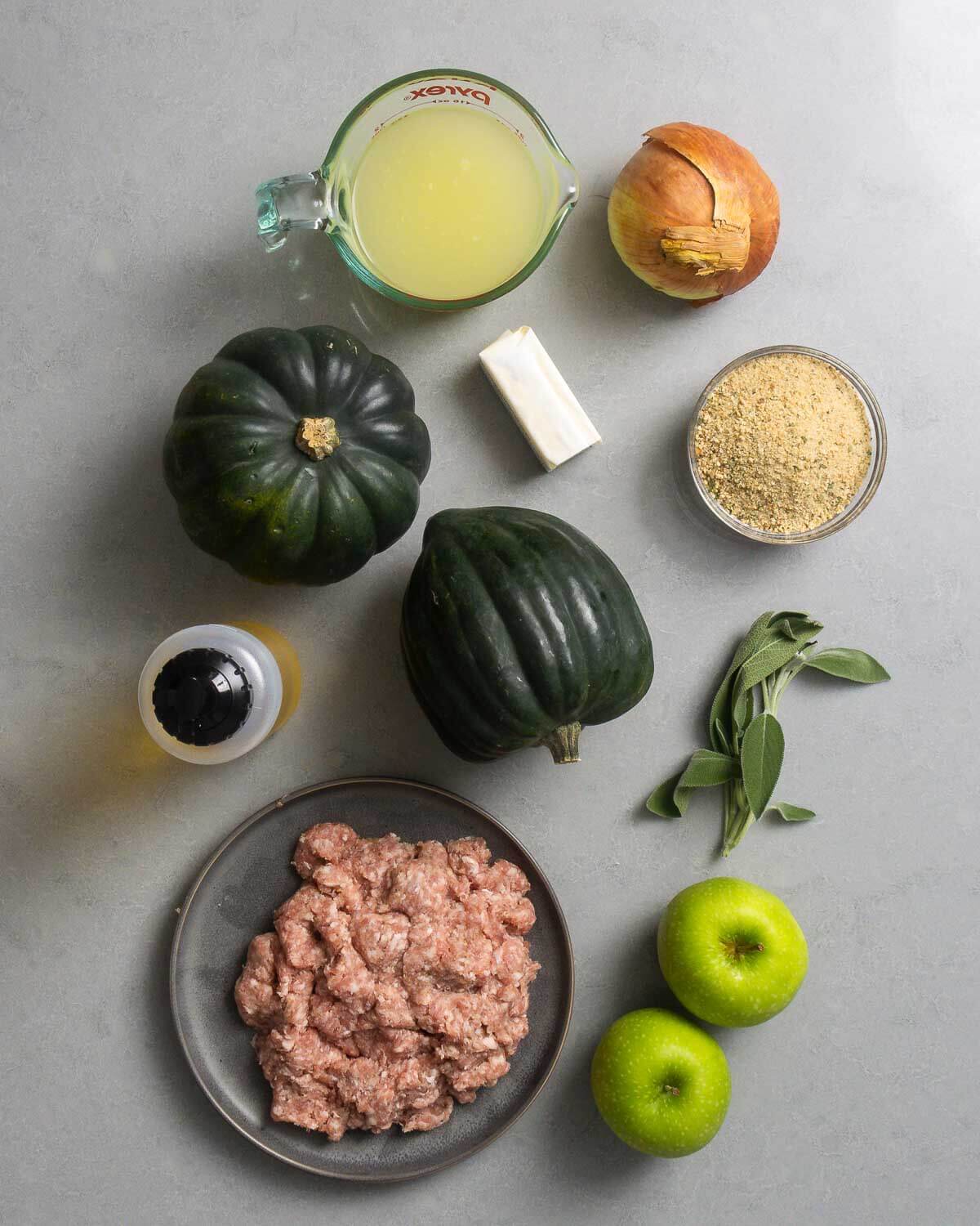 Ingredients shown: chicken stock, onion, acorn squash, butter, breadcrumbs, olive oil, sage, bulk Italian sausage, and apples.