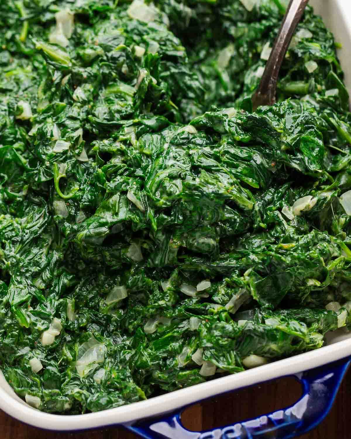 Closeup shot creamed spinach in blue plate.