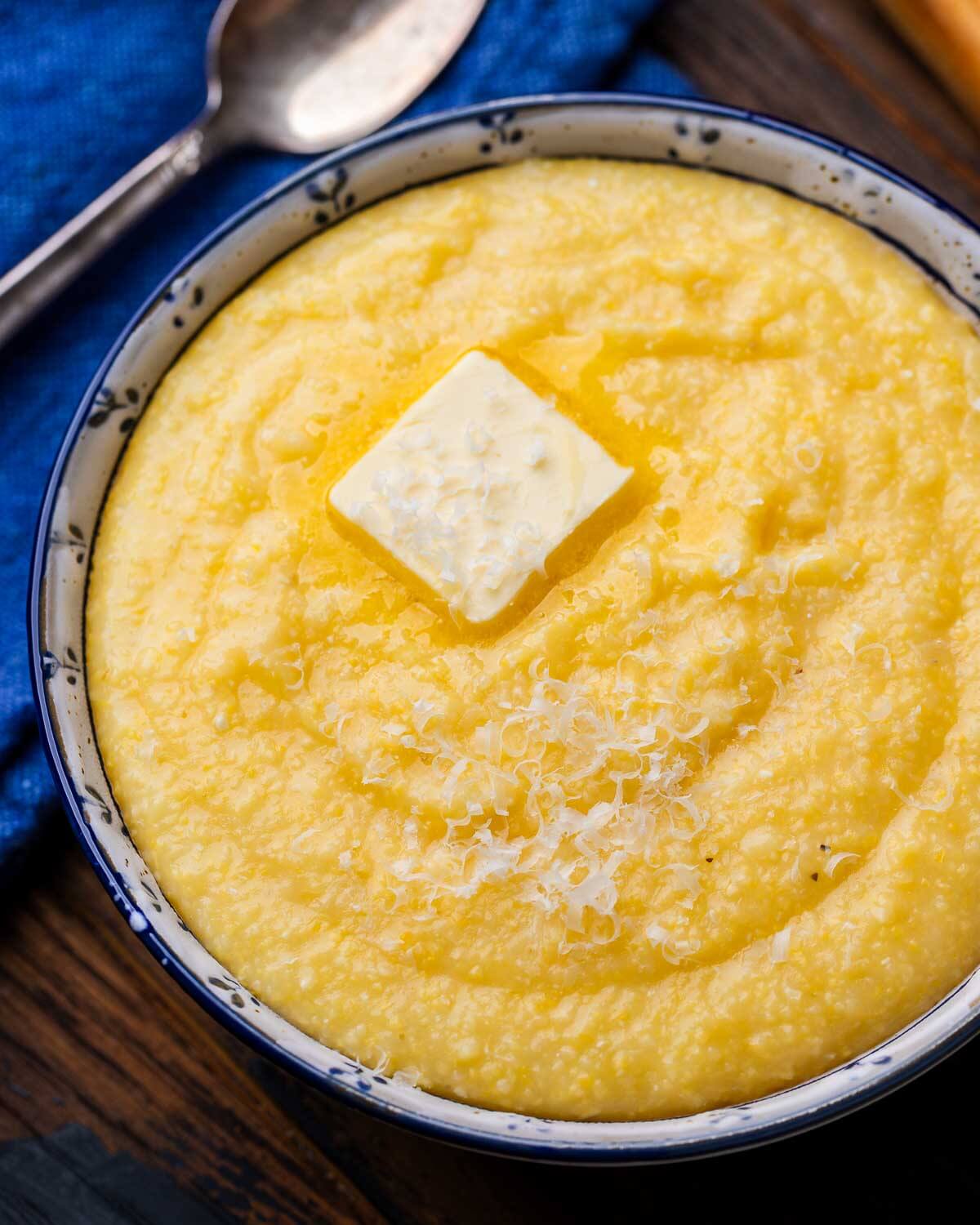 White and blue bowl with creamy polenta and melted butter.
