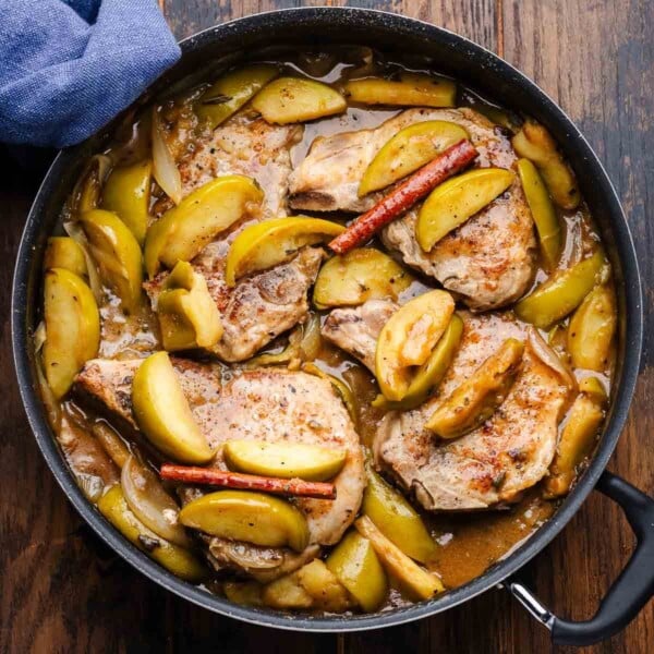 Featured image of large black pan with pork chops and apples.