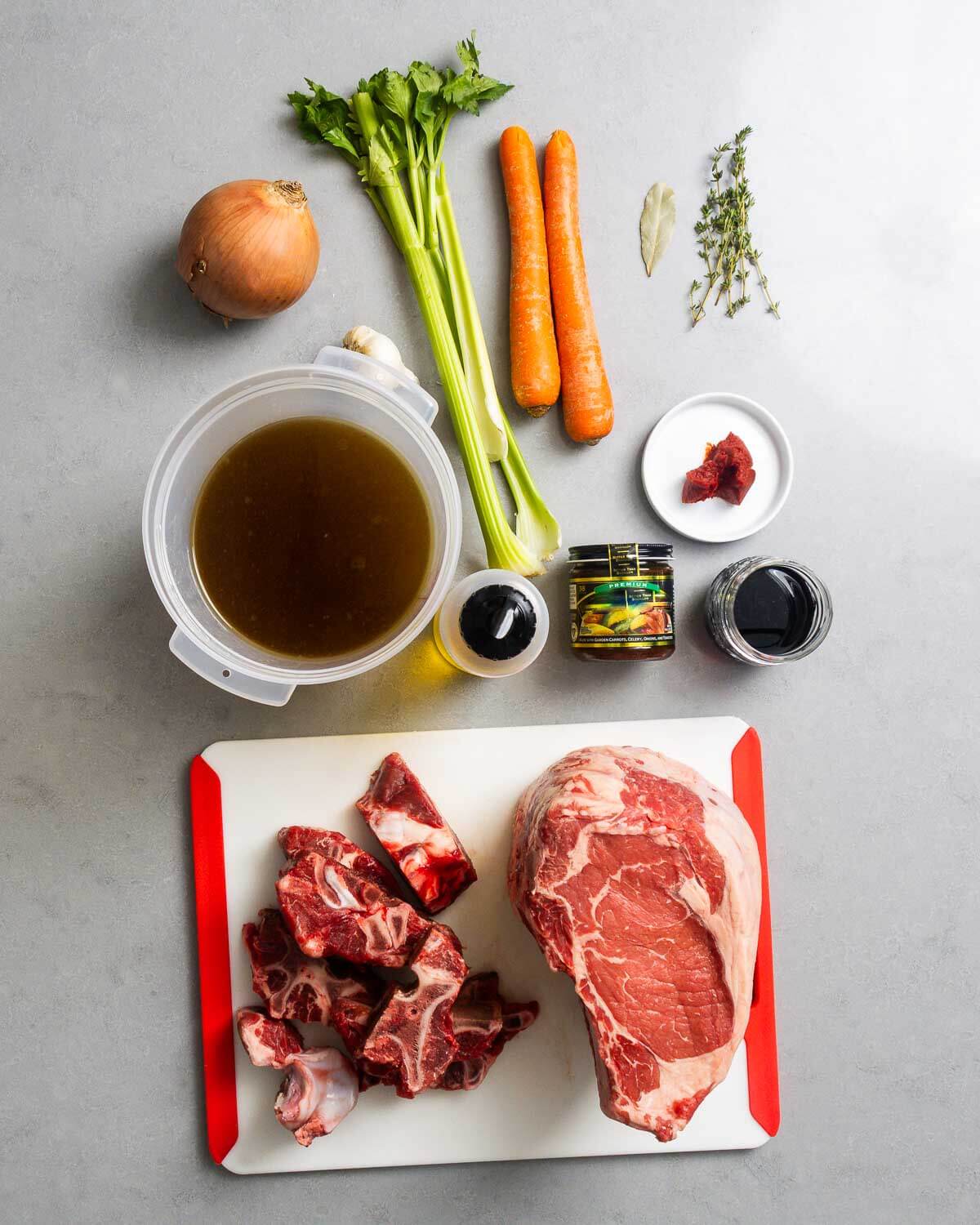 Ingredients shown: onion, celery, carrots, bay leaf, thyme, beef stock, olive oil, beef base, red wine, tomato paste, beef bones, and prime rib.