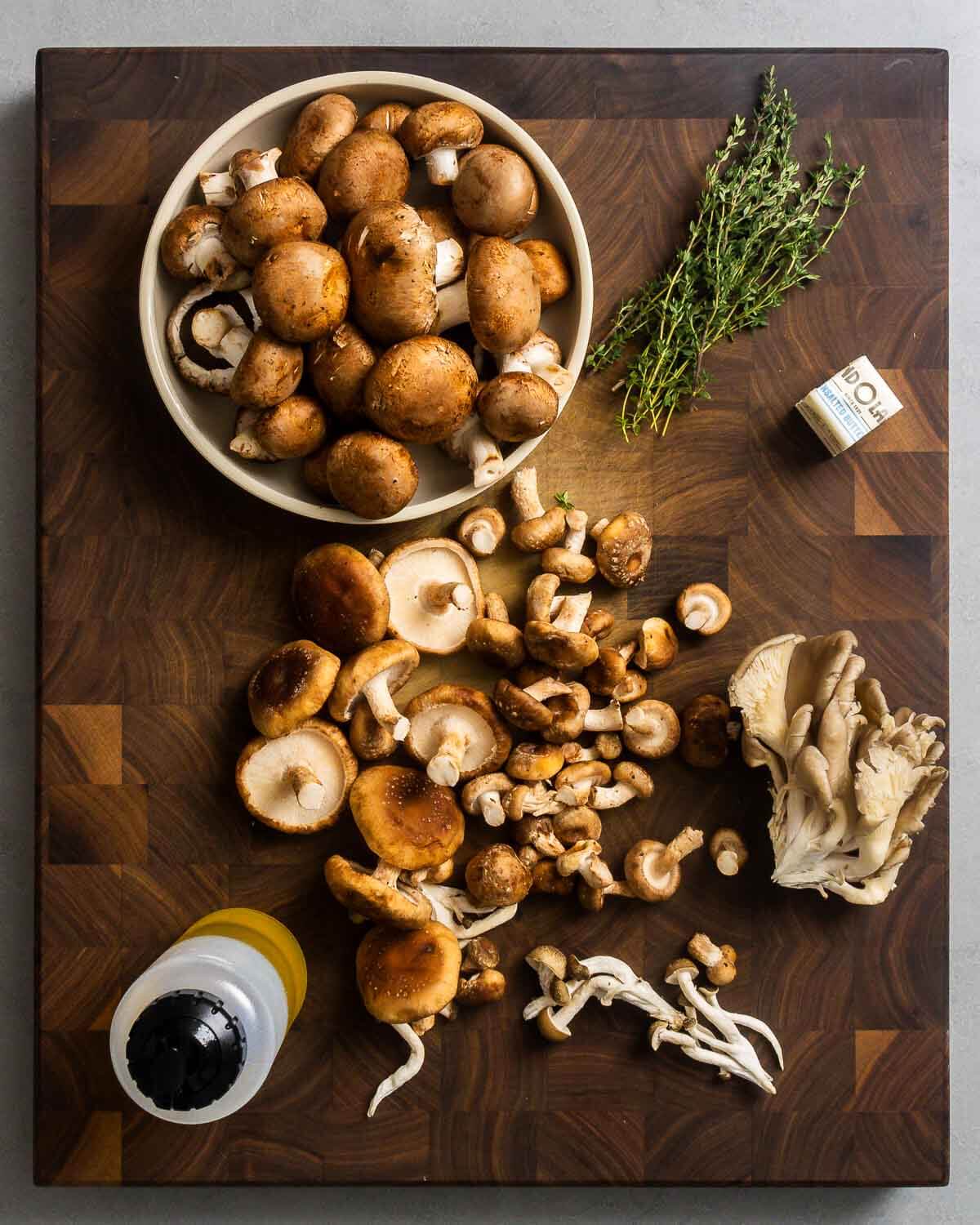Ingredients shown: assorted mushrooms, thyme, butter, and olive oil.
