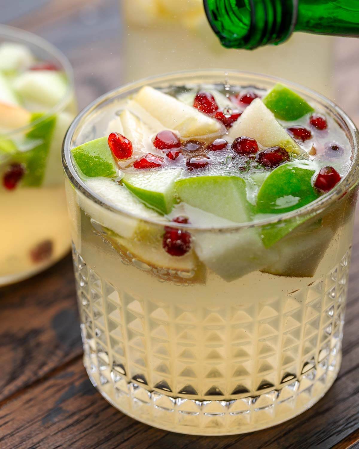 Sparkling water being poured into a glass of sangria.