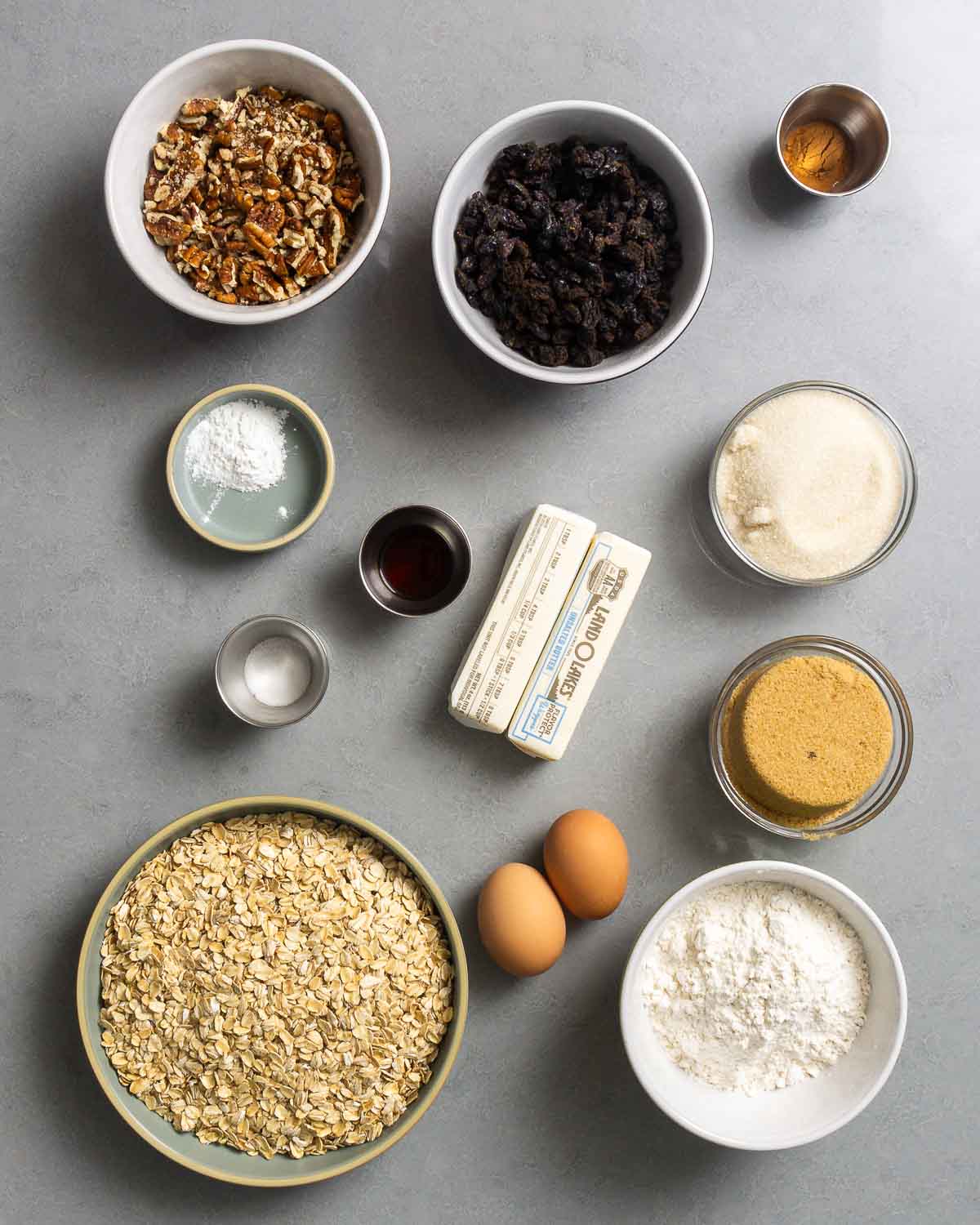 Ingredients shown: pecans, raisins, cinnamon, baking powder, vanilla, salt, butter, sugar, brown, saugar, oats, eggs, and flour.