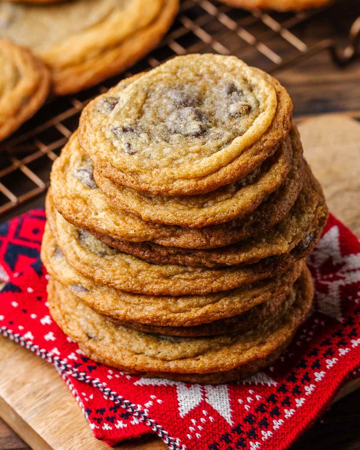 Stack of chocolate chip cookies on red Christmas towel.