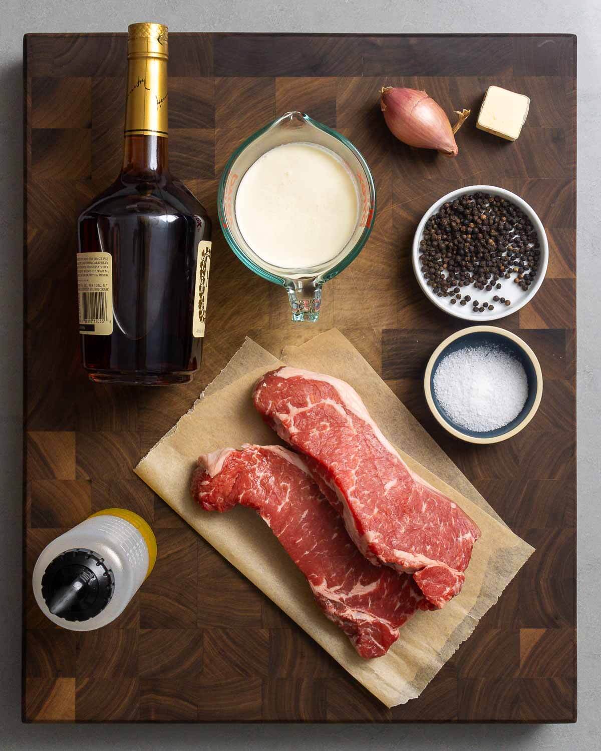 Ingredients shown: cognac, heavy cream, shallot, butter, peppercorns, salt, New York strip steaks, and olive oil.