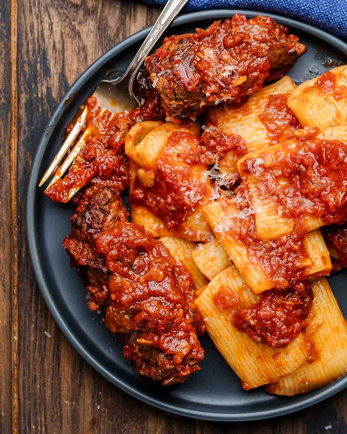 Beef braciole in grey plate with pasta.