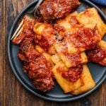 Beef braciole in grey plate with pasta for featured image.