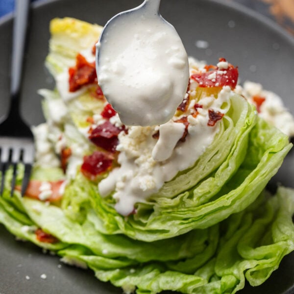 Blue cheese dressing drizzled over lettuce for featured image.