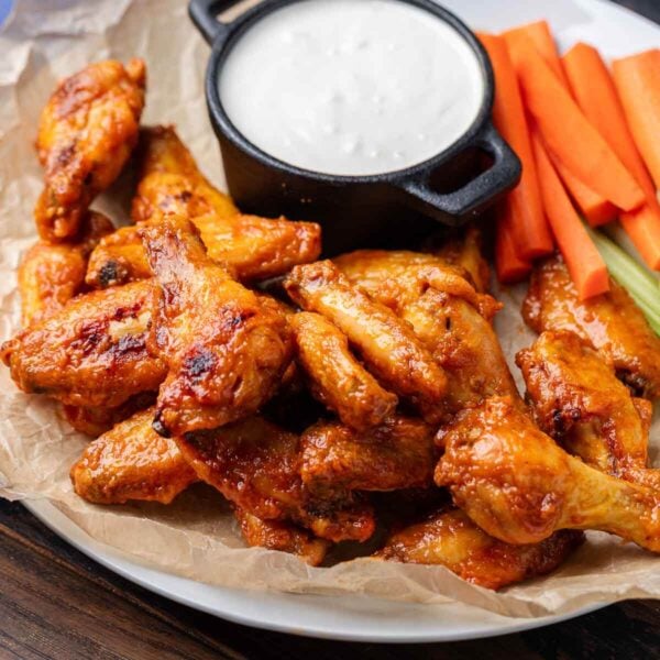 Platter of oven baked buffalo wings with blue cheese, carrots, and celery for featured image.