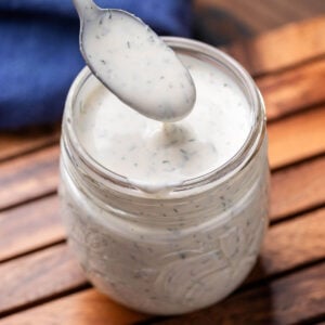 Jar of buttermilk ranch dressing with spoon.