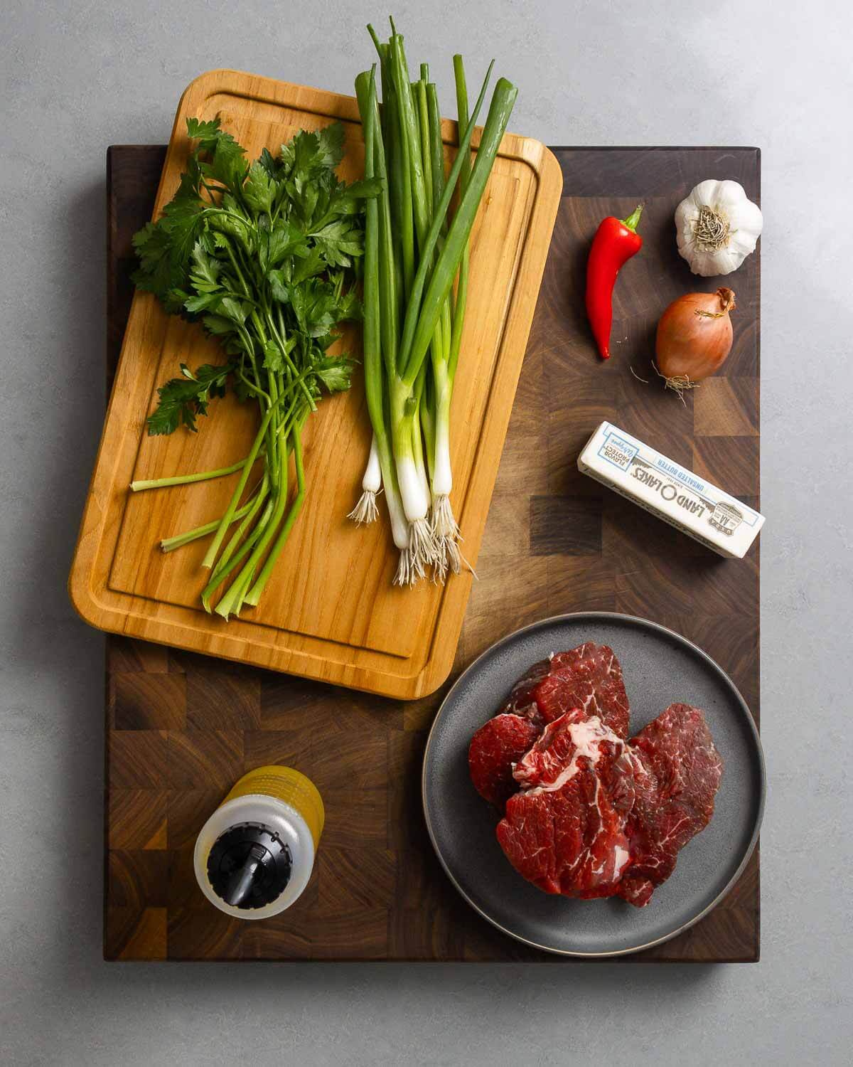 Ingredients shown: parsley, green onions, chili pepper, garlic, shallot, avocado oil, and filet mignon.