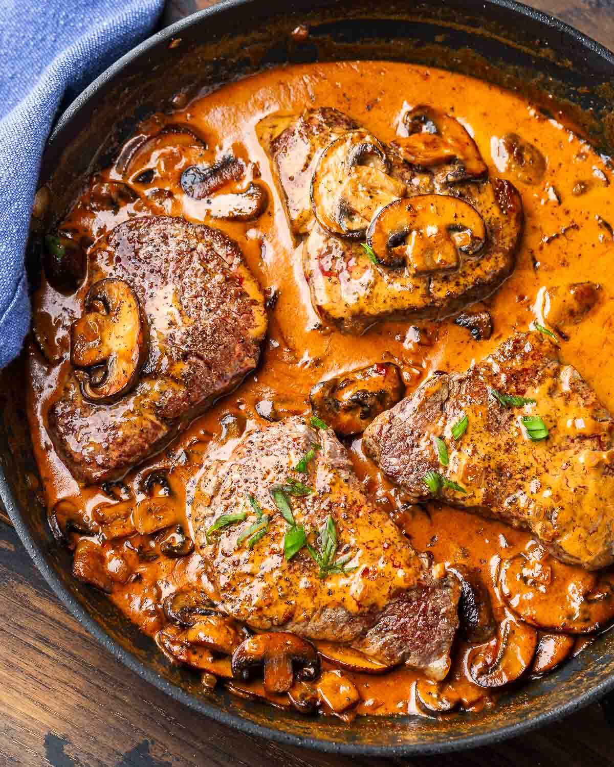 Black pan with Steak Diane in creamy mushroom sauce.