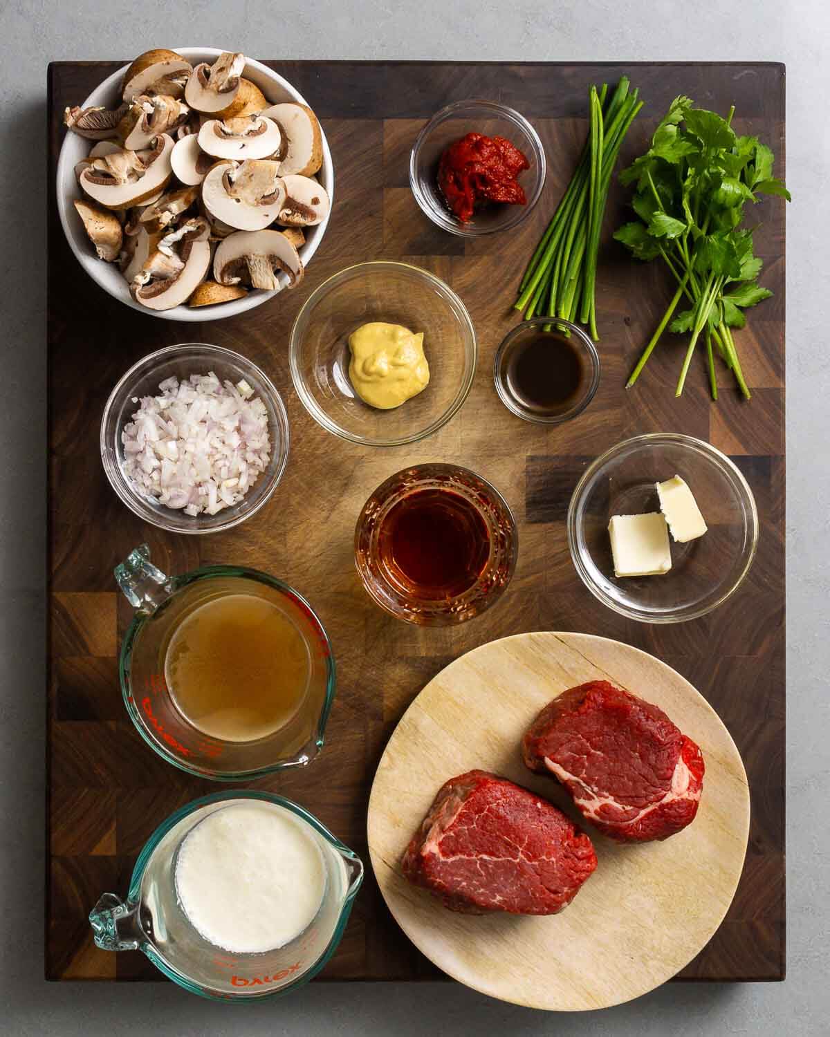 Ingredients shown: mushrooms, tomato paste, chives, parsley, shallot, Dijon mustard, brandy, butter, Worcestershire sauce, beef stock, cream, and beef tenderloin.