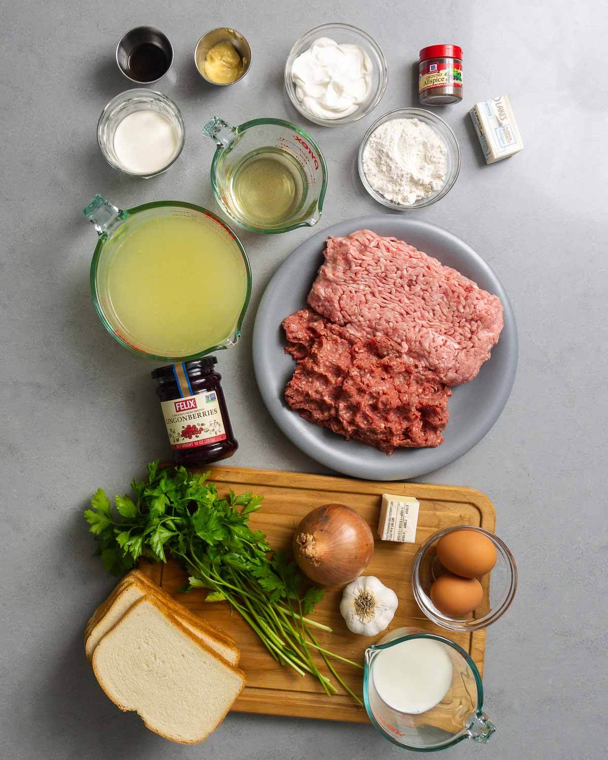 Ingredients shown: Worcestershire sauce, Dijon, heavy cream, sour cream, white wine, flour, allspice, butter, chicken stock, ground beef and pork, lingonberry jam, parsley, white bread, onion, garlic, eggs, and milk.