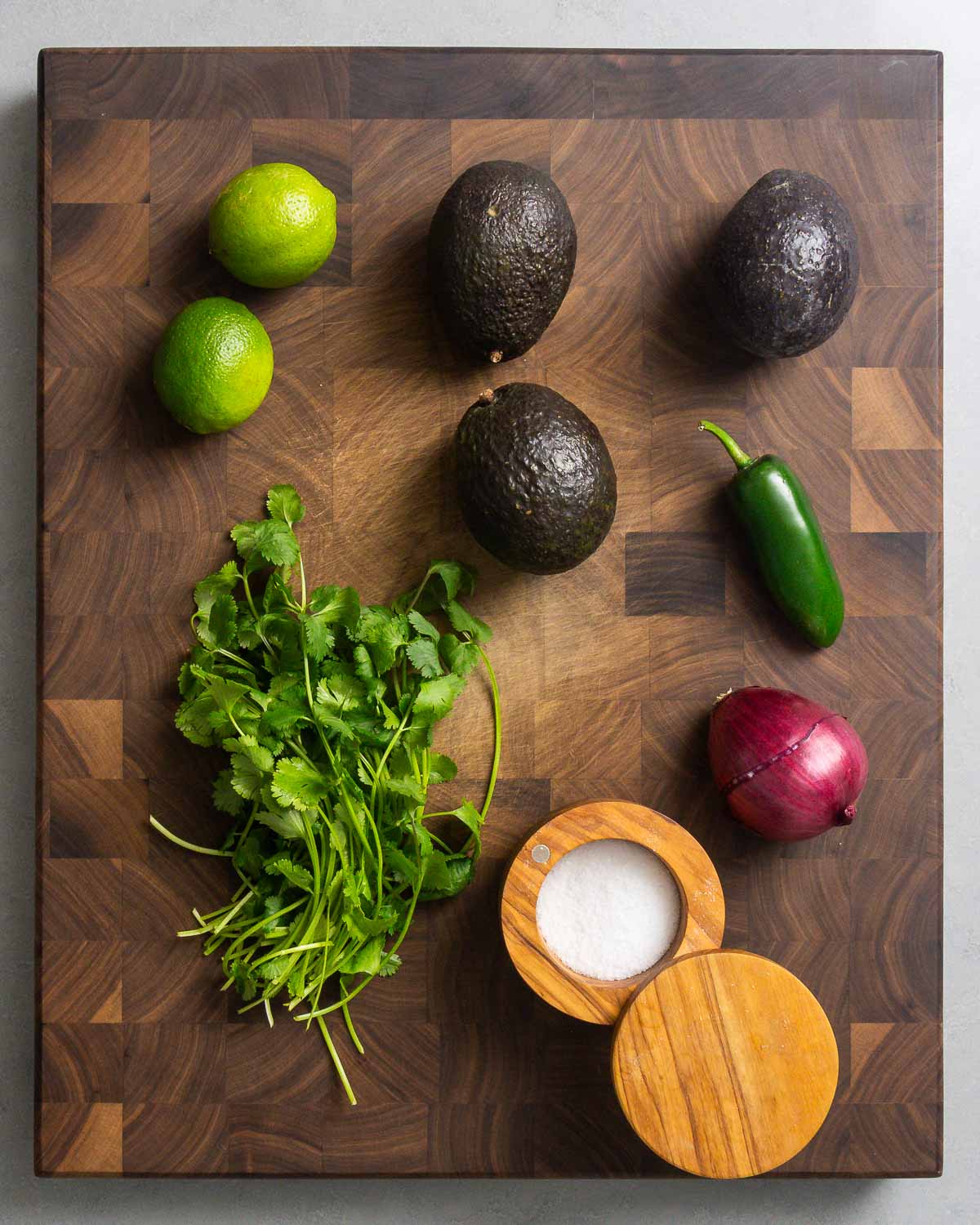 Ingredients shown: limes, avocados, jalapeno pepper, cilantro, onion, and salt.