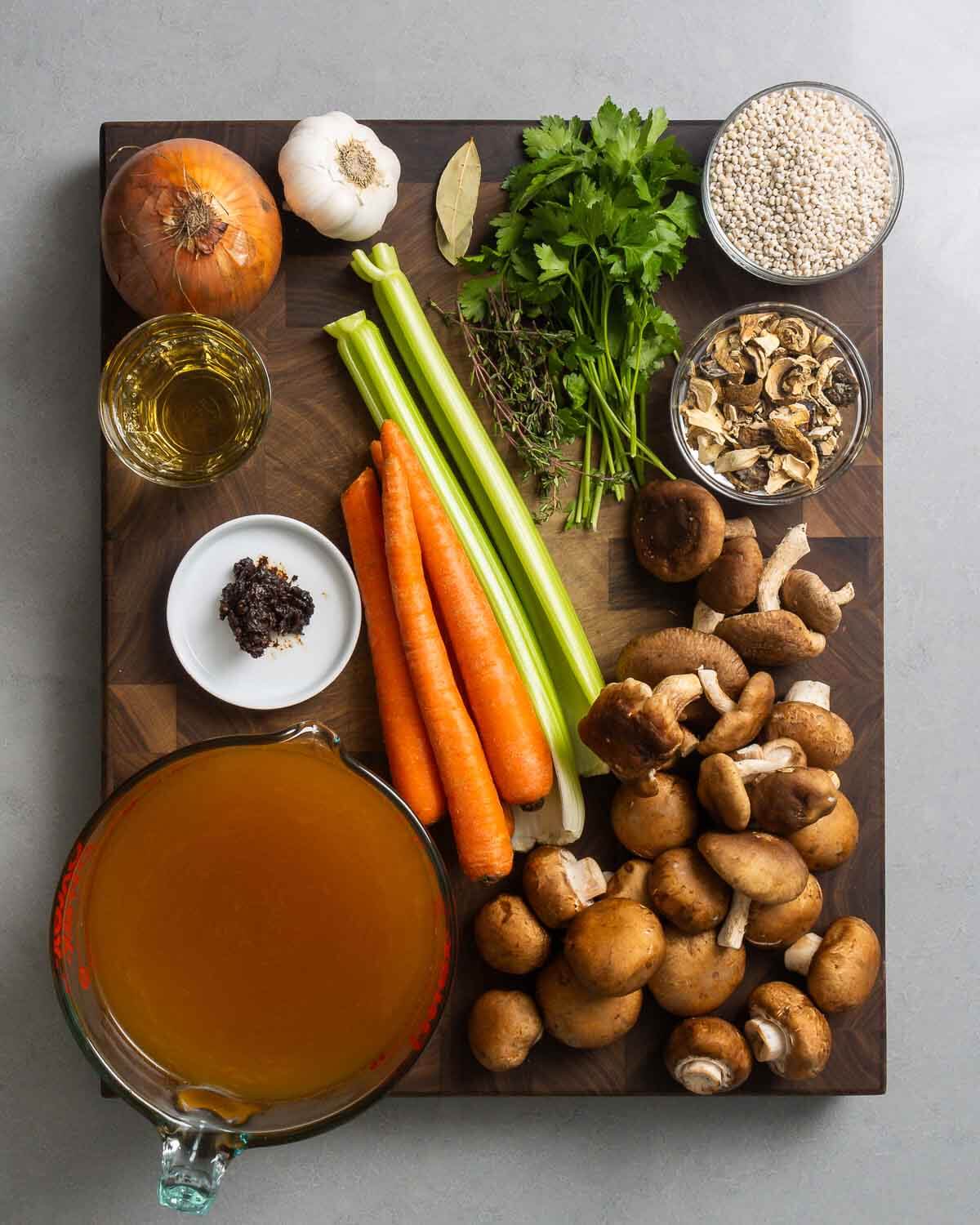 Ingredients shown, onion, garlic, herbs, barley, dry mushrooms, wine, miso paste, celery, carrots, mushrooms, and vegetable stock.