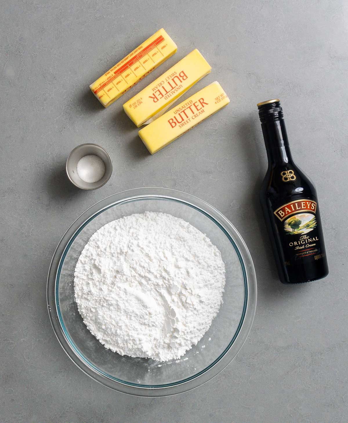 Baileys buttercream frosting ingredients shown: butter, salt, Baileys, and powdered sugar.