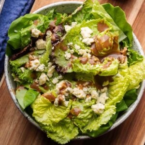 Balsamic vinaigrette on lettuce in white bowl for featured image.