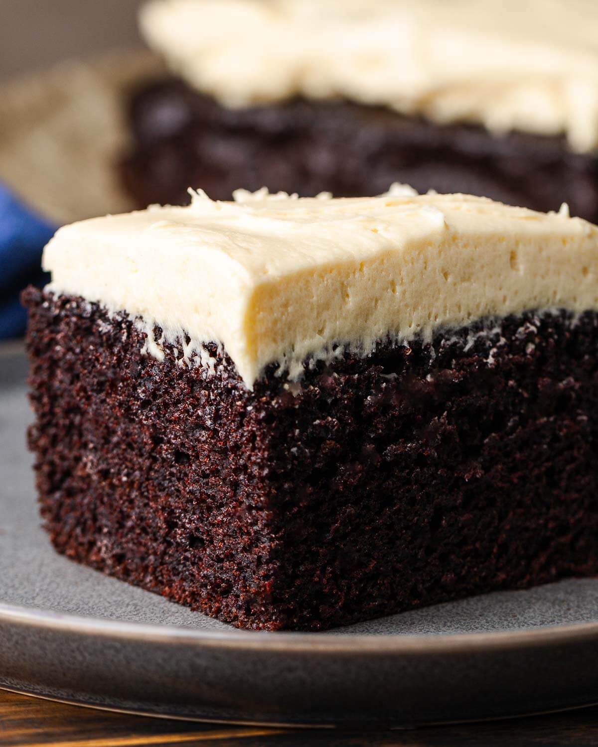 Piece of chocolate Guinness cake on grey plate.