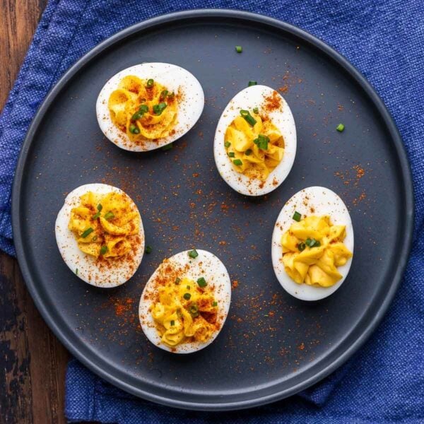 Deviled eggs on blue plate for featured image.