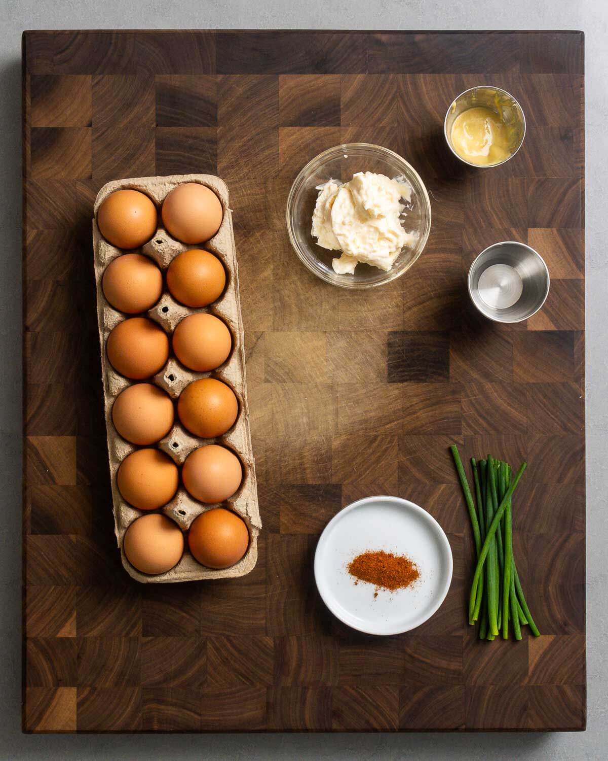 Ingredients shown: dozen eggs, mayonnaise, Dijon mustard, vinegar, paprika, and chives.