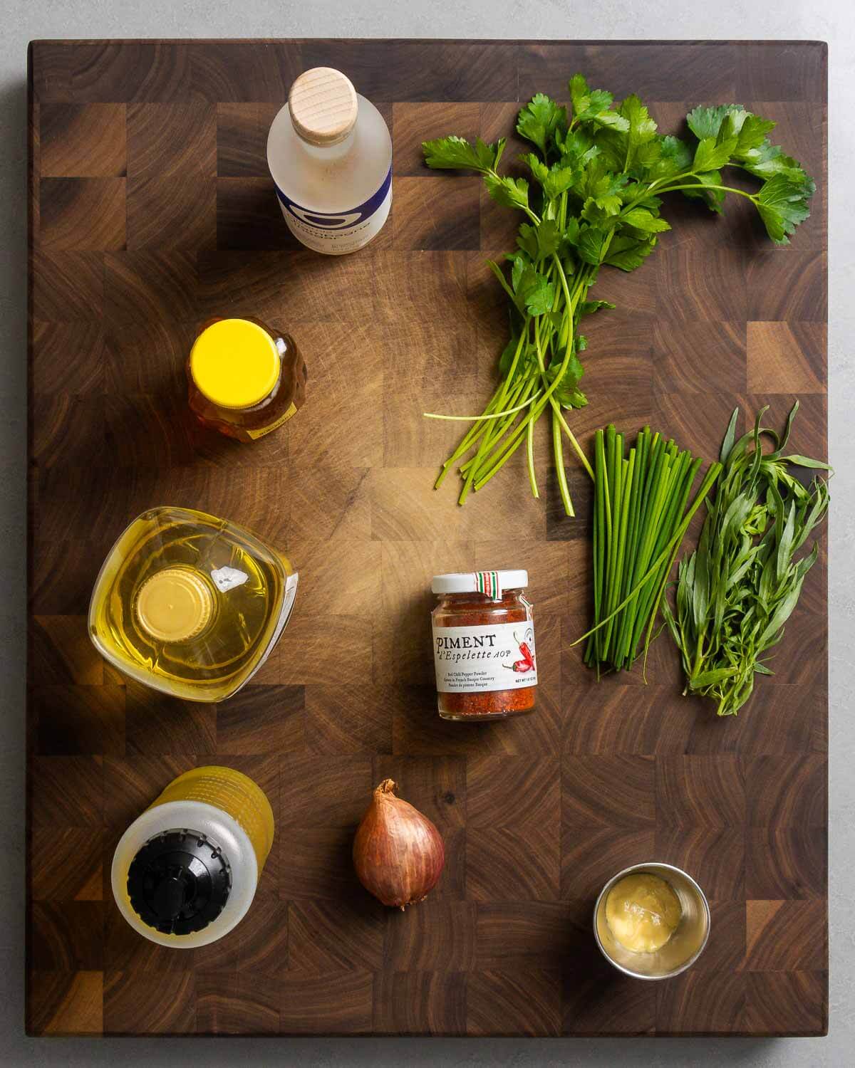 Ingredients shown: champagne vinegar, honey, sunflower oil, olive oil, Piment d'Espelette, shallot, Dijon mustard, parsley, chives, and tarragon.