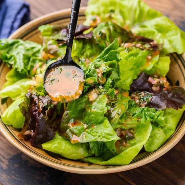 French vinaigrette spooned over salad in bowl for featured image.