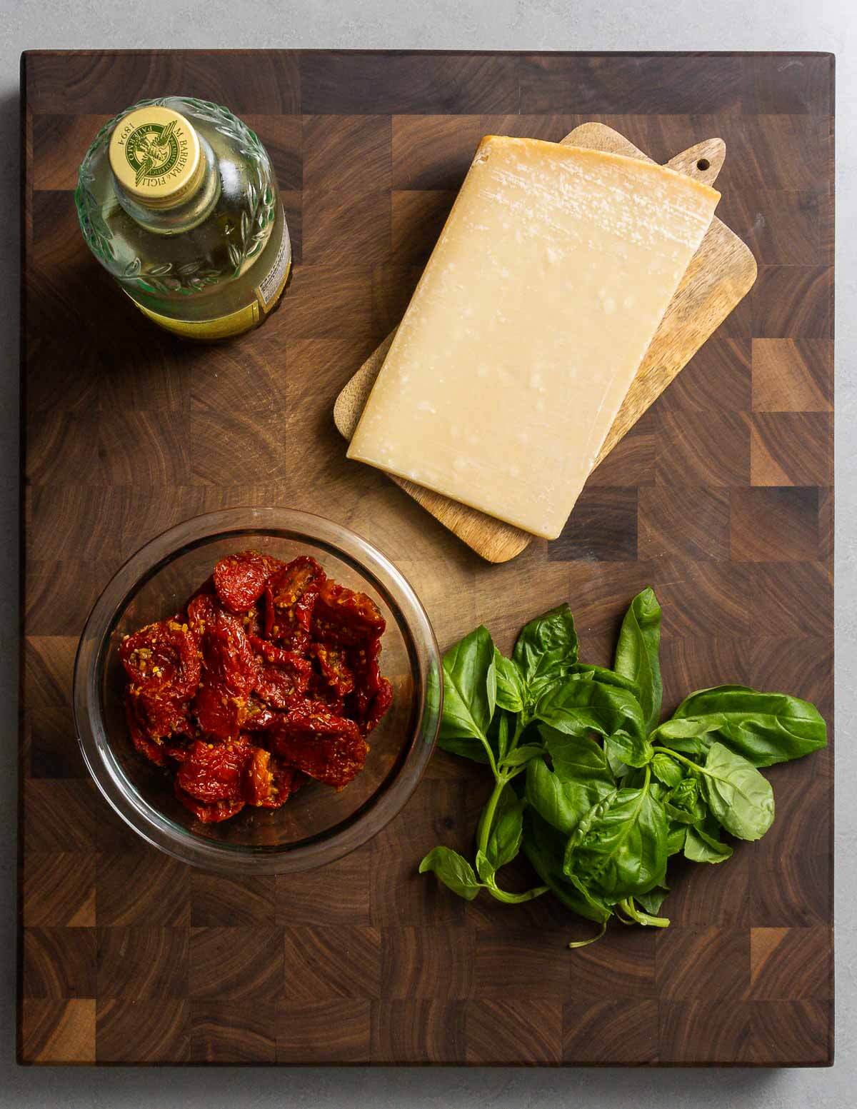 Ingredients shown: extra virgin olive oil, Parmigiano Reggiano, sun dried tomatoes, and basil.