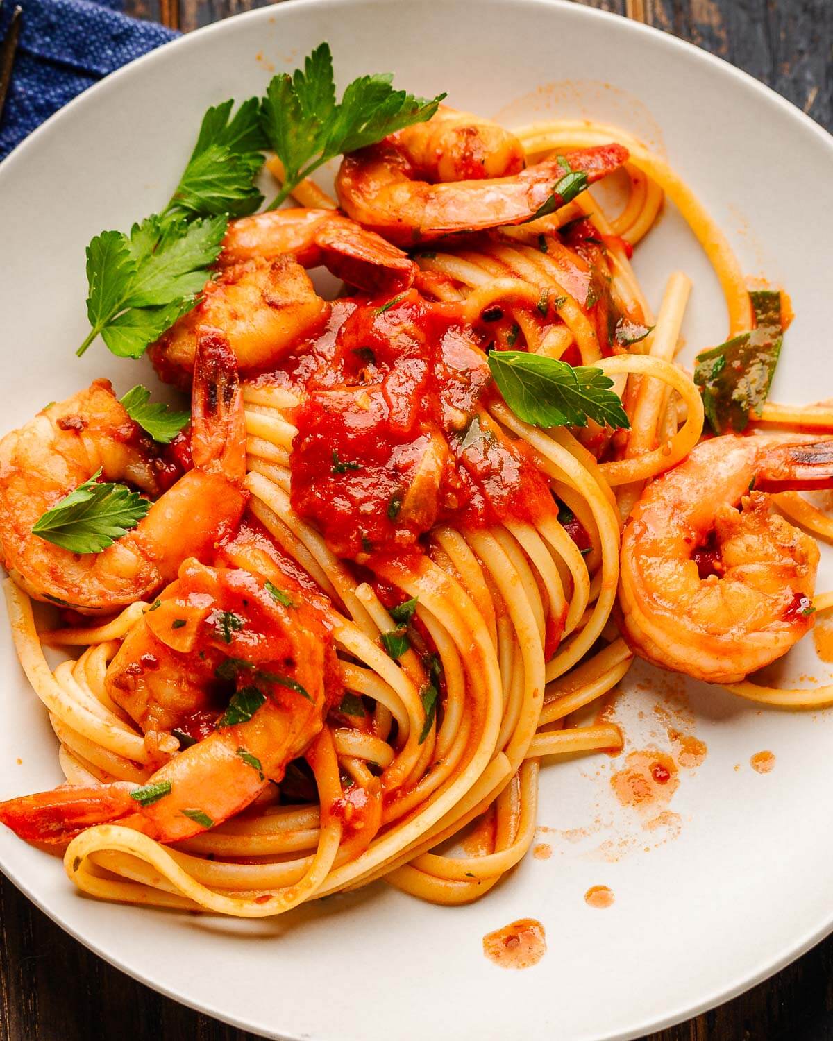 Shrimp fra diavolo on white plate with parsley garnish.