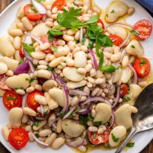 Italian white bean salad piled high on white platter.