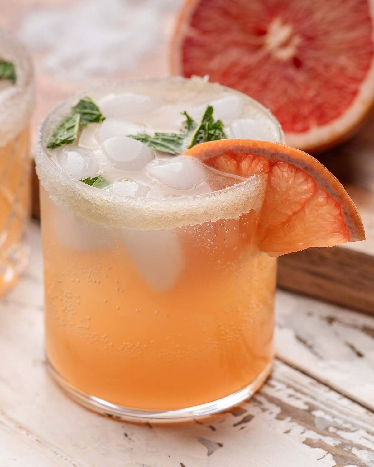 Paloma in glass with grapefuit and mint garnish.