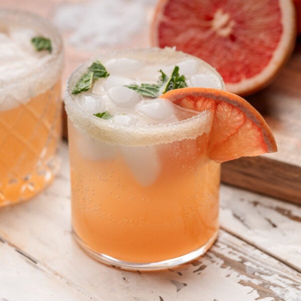 Paloma in glass with grapefuit and mint garnish.