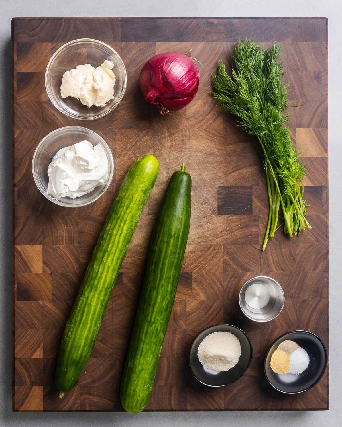 Ingredients shown: mayonnaise, sour cream, red onion, dill, English cucumbers, white vinegar, sugar, salt, pepper, and granulated garlic.