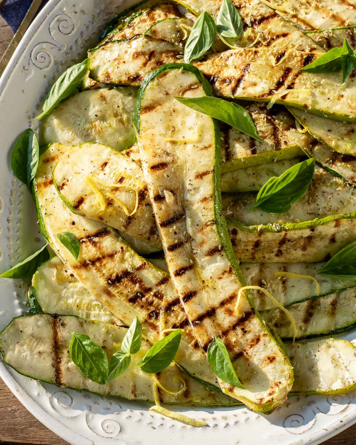 Grilled zucchini with basil leaves for garnish.