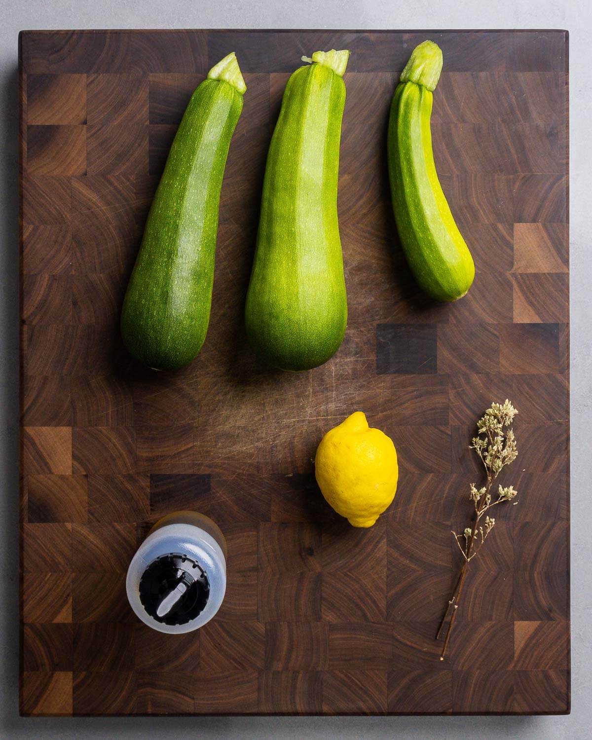 Ingredients shown: zucchini, olive oil, lemon, and Sicilian oregano.