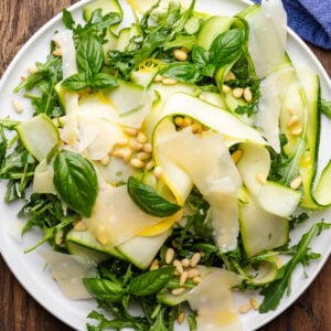 Shaved zucchini salad on white platter.