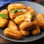 Plate of Italian potato croquettes with one cut in half.