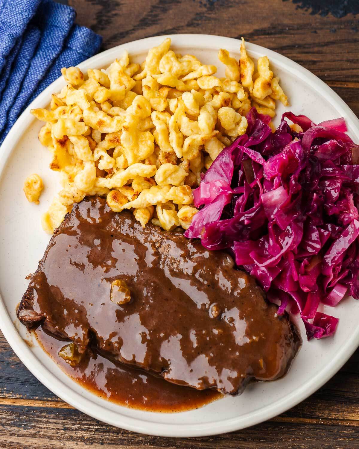 Plate with spaetzle, sauerbraten, and red cabbage.