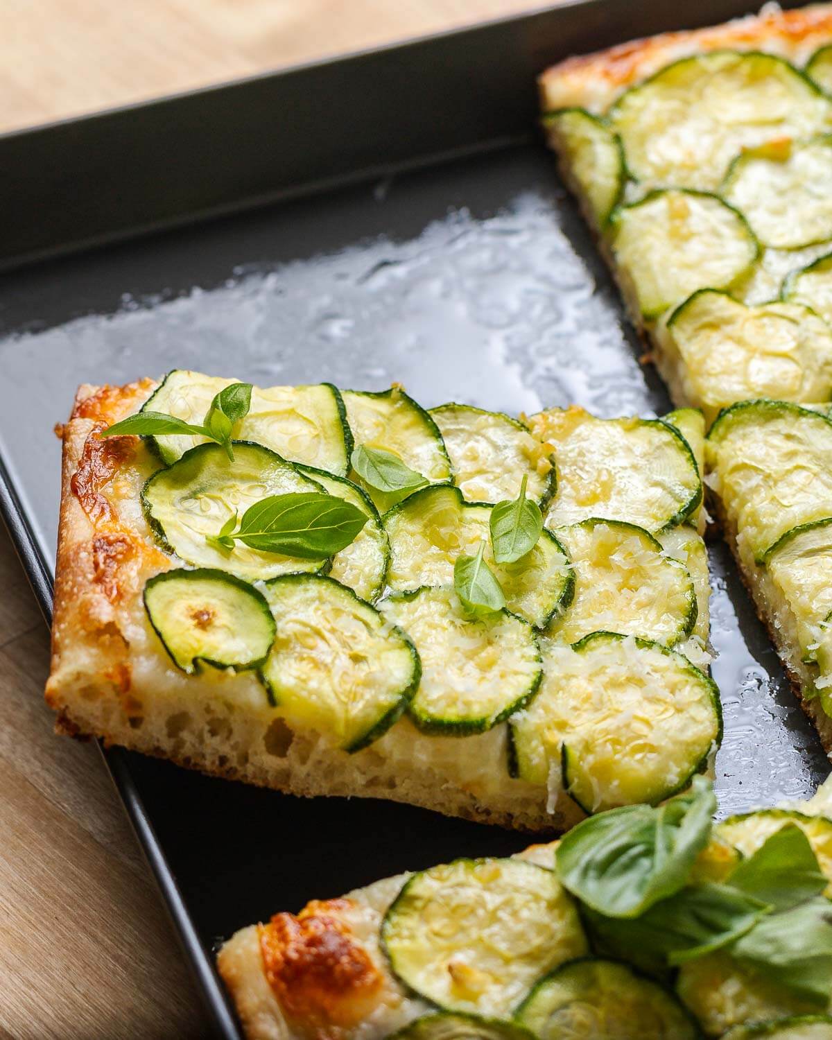 One slice of zucchini pizza showing the crumb texture from the side.