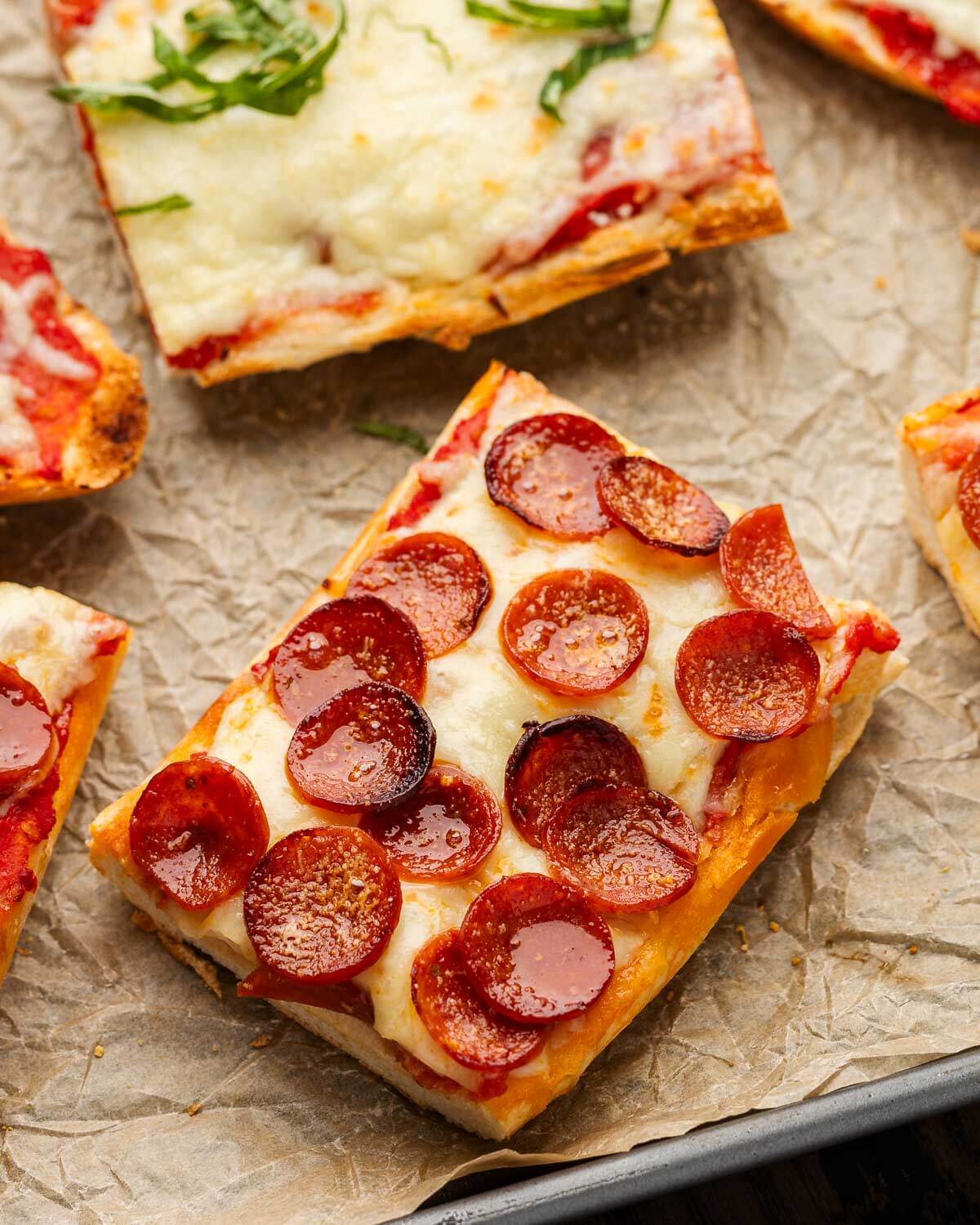 Closeup shot of cut French bread pizza slice with pepperoni.