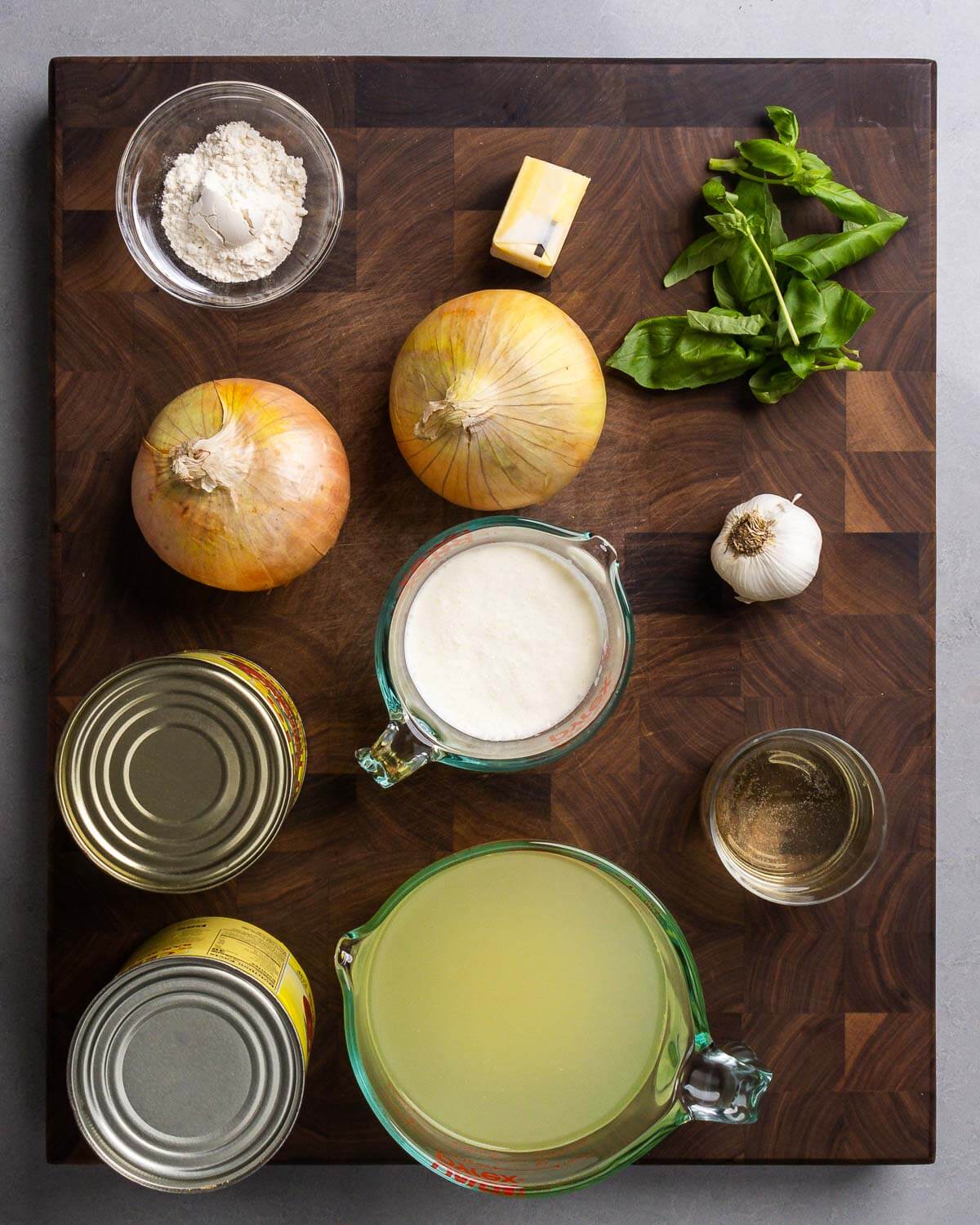 Ingredients shown: flour, butter, onions, basil, crushed tomatoes, heavy cream, garlic, white wine, and chicken stock.