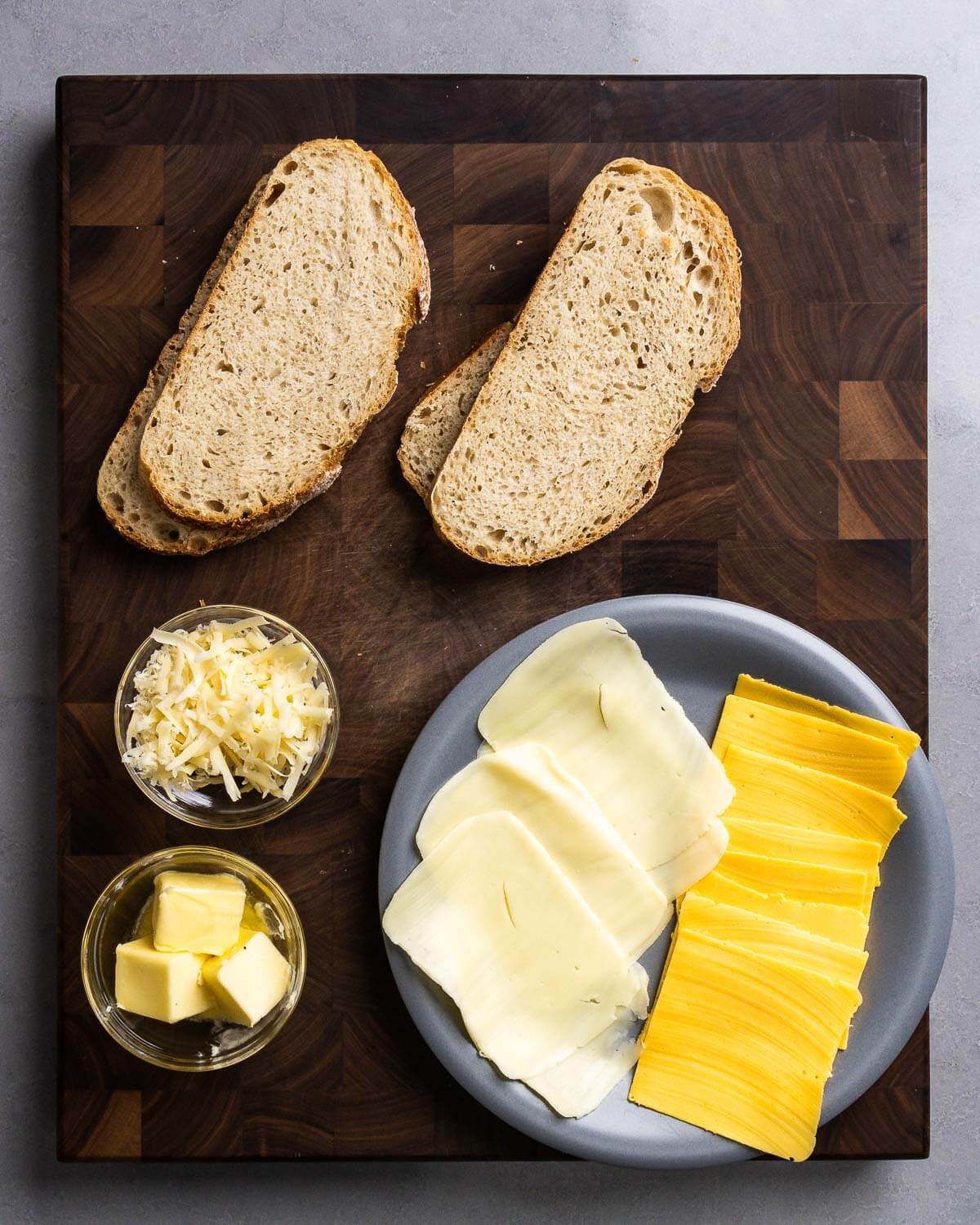 Ingredients shown: sourdough bread, shredded Fontina, mozzarella and American cheese slices, and butter.