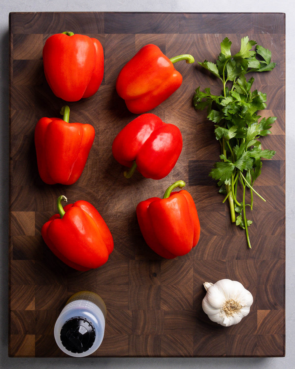 Ingredients shown: red bell peppers, parsley, olive oil, and garlic.