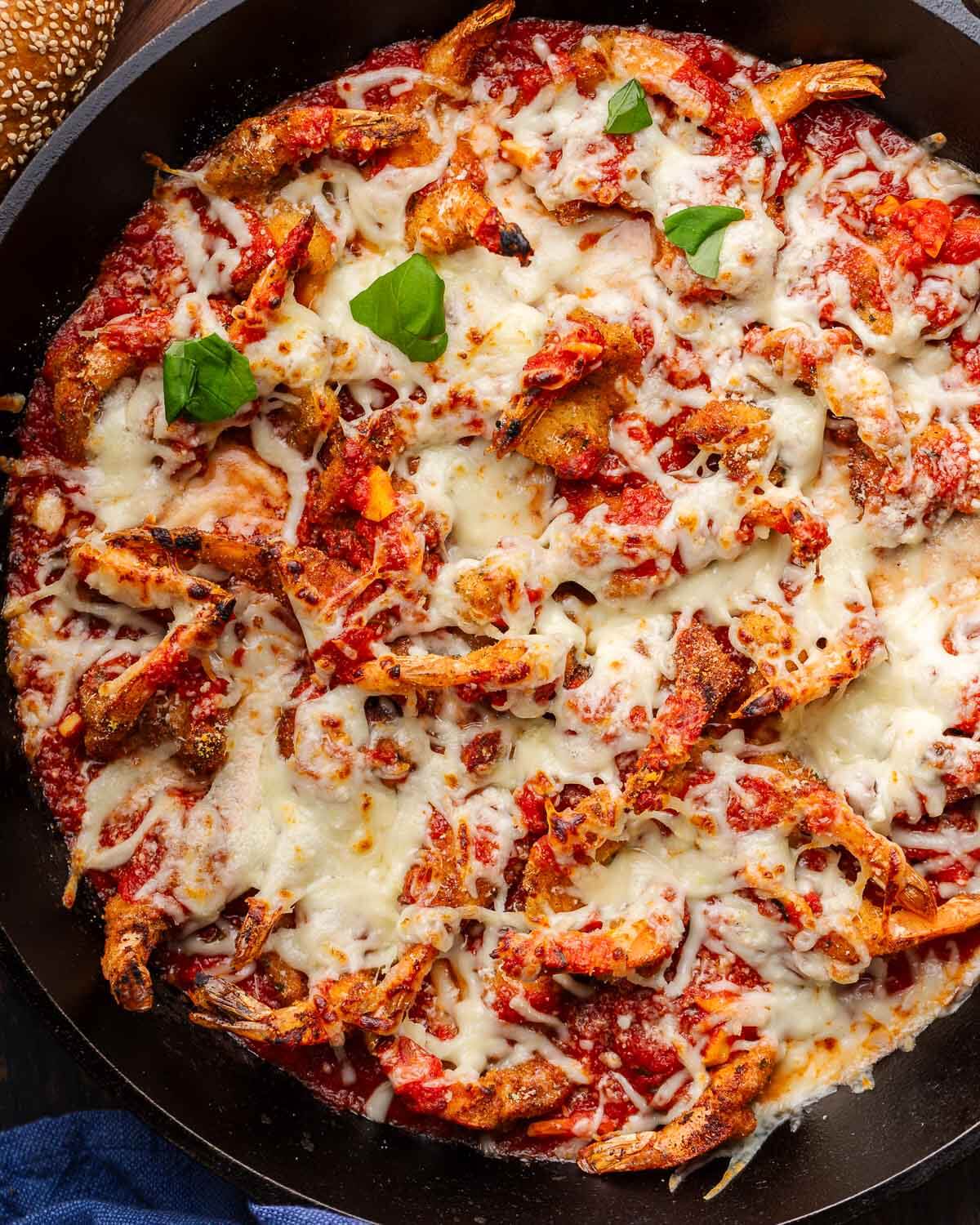Large cast iron pan with shrimp parmigiana.